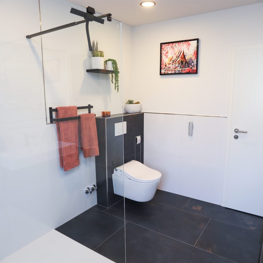 Nachher: bodengleiche Dusche mit Glaswand neben wandhängendem WC